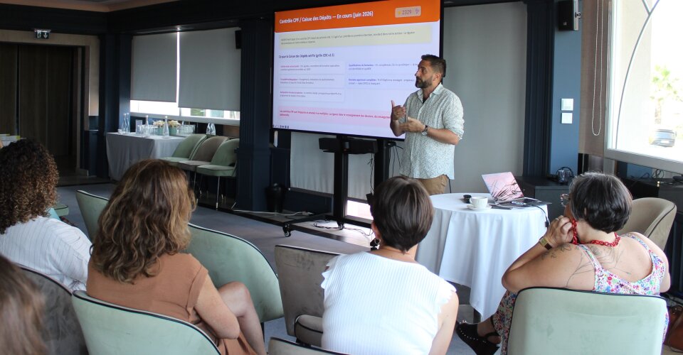 Salle de formation avec formateur devant un écran