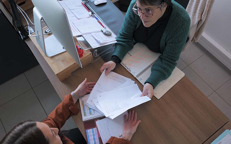 conseillère donnant des document à une autre personne