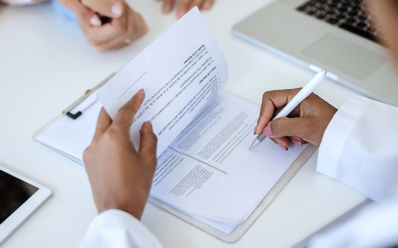 gros plan sur les mains d'une infirmiere faisant une ordonnance