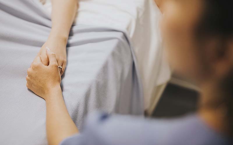 infirmière tenant la main d'un patient